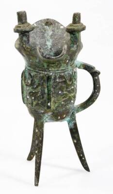 A Chinese bronze jue, with a double lipped body raised with a geometric pattern, with side handle, on triple supports, 15cm H. - 3