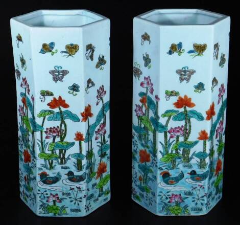 A pair of 20thC Chinese pottery vases, each of hexagonal form, profusely decorated with water lilies, insects and flowers, predominately in green, pink and red, seal marks beneath, 28cm H.