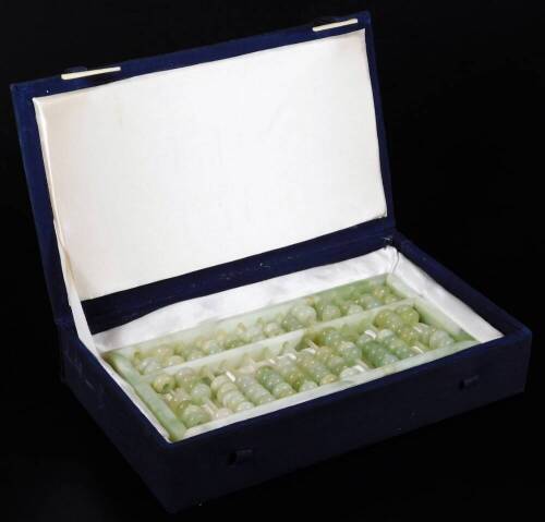 A polished green jade coloured abacus, of rectangular form, set with compressed beads, 25cm W. (boxed)