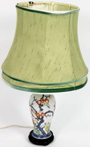 A 20thC Chinese porcelain table lamp, the shouldered circular body polychrome decorated with flowers predominately in green and orange, with lamp fittings, 39cm H.