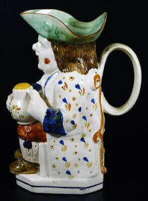 An early 19thC Prattware Toby jug, the toper sat in floral jacket picked out in yellow, holding a jug, aside pipe, with green hat, orange breeches and brown shoes, 24cm H. - 3