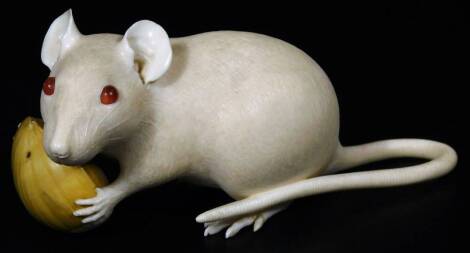 A fine late Meiji period ivory figure of a rat holding a nut, three character red seal mark, the rat with semi precious stone eyes, 14cm L.