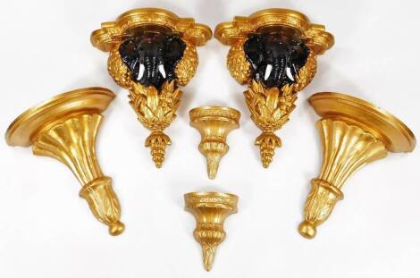 A pair of gilt wood wall brackets, each heavily carved with shaped stands above elephants, acanthus leaves and berries, 34cm H, two further gilt wood acanthus wall brackets and two metal sconces of small proportion. (6)