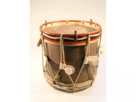 A regimental snare drum with brass body and painted wooden mount with brass