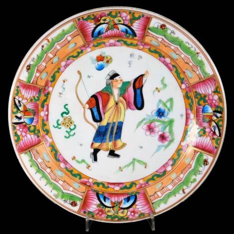 A Cantonese famille rose semi porcelain plate, of circular form centred by figure holding bow, with a border set with panels of butterflies and arches, predominantly in pink, green and blue, 22cm Dia.