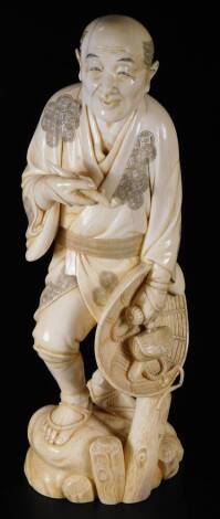 A Japanese Masayuki Meiji period ivory okimono figure, of a gentleman in flowing robes holding pipe and hat, on a naturalistic base, red seal mark beneath, 30cm H.