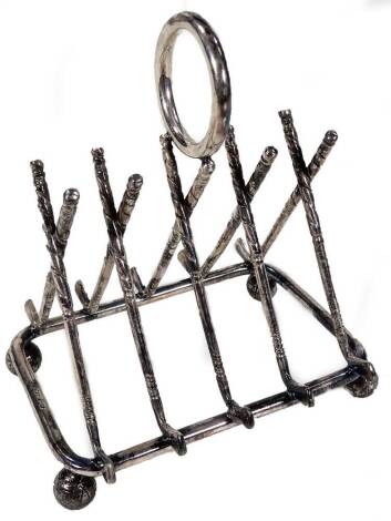 An early 20thC silver plated novelty toast rack, with four golf club sections on golf ball feet, centred by a circular handle, 12cm H.
