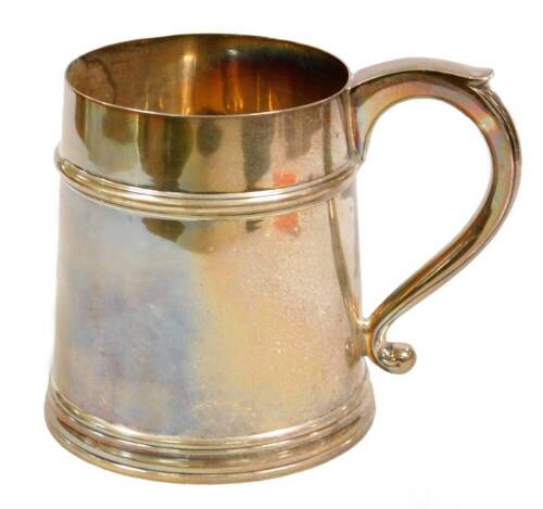 A George V silver tankard, the cylindrical tapering body with thumb mould acanthus leaf handle on a circular foot, Sheffield 1923, 12cm H, 15½oz. (weighted)