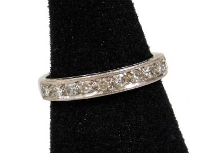 An 18ct white gold half hoop eternity ring, set with tiny diamonds in claw setting, ring size O, 3.9g all in.