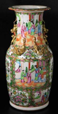 A Cantonese famille rose floor standing vase, with a compressed trumpet stem and shouldered body, raised with gilt coloured dragons, profusely decorated with panels of birds and figures in an interior setting, on circular foot, 47cm H.