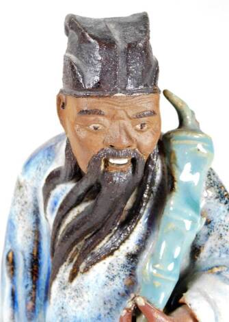 A Chinese Ming style pottery figure of a standing bearded sage, in flowing robes, partially coloured in blue and green, unmarked, 26cm H.