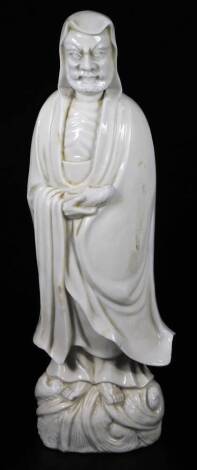 A Chinese porcelain blanc de chine figure, of a bearded sage standing in flowing robes, 38cm H. (hollow)