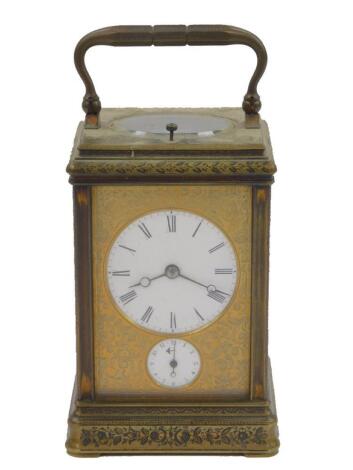 A late 19thC French brass cased repeater carriage clock, the gilt dial fascia with floral and foliate engraving, circular enamel dial bearing Roman numerals, subsidiary alarm dial, twin barrel movement by Alfred Drocourt, with coil strike, serial no 10491