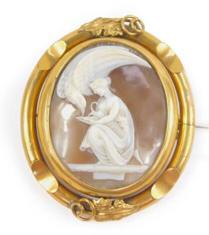 A 19thC shell cameo brooch, carved as Juventas kneeling before Zeus in the guise of an eagle, in a yellow metal frame, with safety chain as fitted, 6cm W, 7cm D, 45.6g.