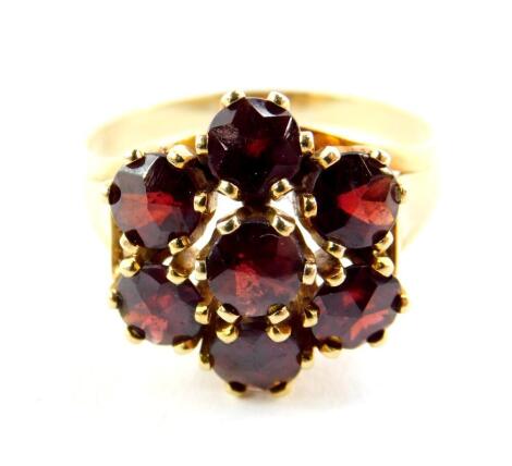 A 14ct gold and garnet flower head ring, set with seven garnets, size U/V, 5.6g.