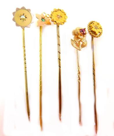 Five stick pins, comprising a a leaf and peridot 9ct pin, a 9ct flower pin, and three Victorian style pins, yellow metal, unmarked.