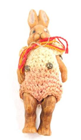 An early 20thC articulated porcelain figure of a rabbit, in a crocheted woollen costume, 7cm H.