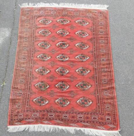 A Tekke Turkoman rug, decorated with geometric motifs against a red ground, 209cm x 143cm.