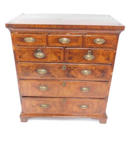 A George II walnut and crossbanded chest of drawers, converted from a chest on chest, with three short over to medium and three long graduated drawers, raised on bracket feet, 114cm H, 101cm W, 54cm D.