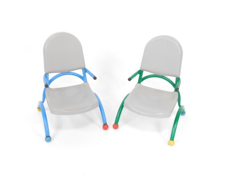 A pair of French MMO NF Education primary school child's chairs, c1999, with blue and green metal frames, grey plastic seats and backs, the legs terminating in coloured ball feet.