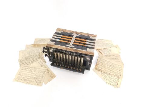 An early 20thC Commander accordion, ten button, boxed with sheet music.