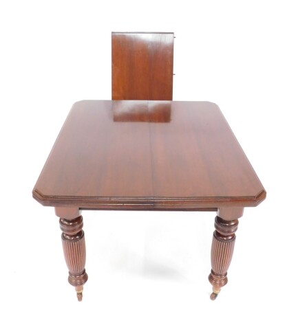 A Victorian mahogany wind-out dining table, with one additional leaf, raised on turned and fluted legs, brass capped on castors, with winder, 73cm H, 95cm W, 141cm extended, 114cm D.