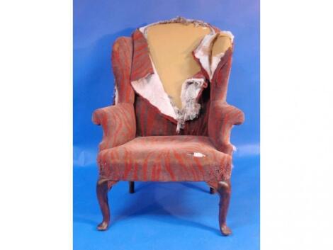 A Georgian wing back upholstered armchair with walnut cabriole legs