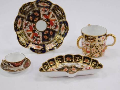 A Royal Crown Derby Imari tyg, floral shaped dish, fan shaped dish, and a miniature tea cup and saucer, printed and painted marks, (AF). (5)