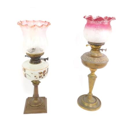 An Eltex brass oil lamp, with embossed and fluted decoration, with chimney and frosted and moulded shade, clear to red, 70.5cm H, together with a Youngs brass and opaline glass oil lamp, painted with autumn leaves, with chimney and etched to clear cranber