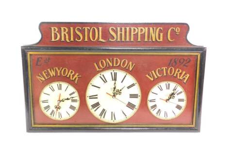 A replica Bristol Shipping Company triple wall clock, three dials showing the times for New York, London, and Victoria, battery operated, 41cm H, 65cm W.