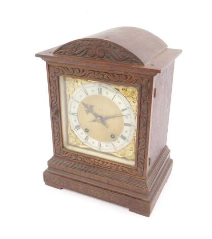 A German late 19thC oak cased mantel clock, square brass dial with cherub spandrels, silvered chapter ring bearing Roman numerals, Winterhalder & Hofmeier 8-day movement with coil strike, the case with carved scroll decoration, 33cm H, 24.5cm W, 17cm D.