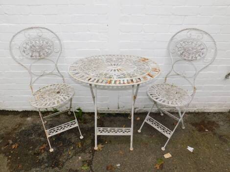 A Victorian style white painted cast iron bistro set, comprising oval table and two chairs, table 74cm H, 71.5cm W. (3)