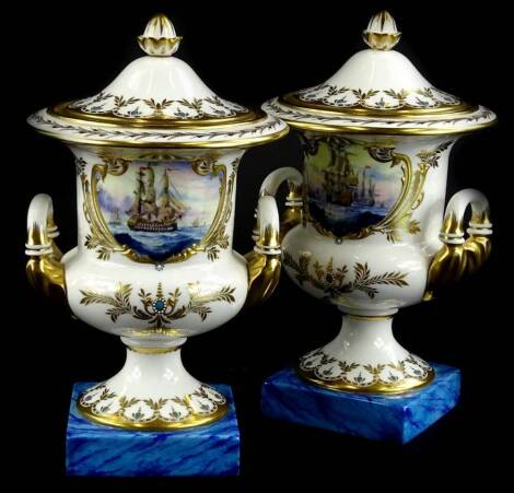 A pair of Lynton porcelain two handled vases and covers, painted by Stefan Nowaki, with shipping scenes with war ships etc., within elaborate gilt and "jewelled" cartouches and a marbled blue base, monogram in blue and printed mark in red to underside.