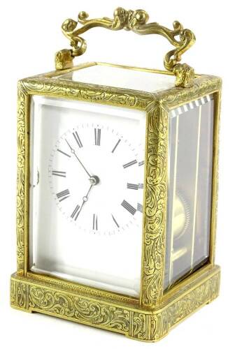 A late 19thC French brass carriage clock, elaborately engraved with foliate scrolls etc., with a white enamel dial, striking on a coiled gong, 16cm H.