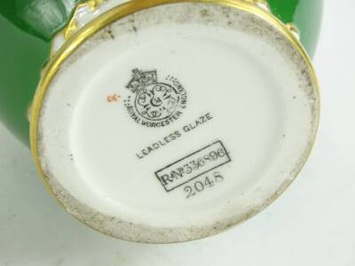 A Royal Worcester porcelain pot pourri jar cover, painted with a flower spray, on a green ground with gilt decoration, printed mark in black to underside, numbered 2048. - 2