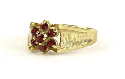 A 9ct gold dress ring, set with garnets, in a floral cluster, ring size T, 1.8g all in.