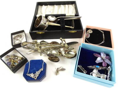 A quantity of costume jewellery and silver plated wares, to include knife press, tea spoons, napkin rings, earrings, bar brooches etc. (1 tin)