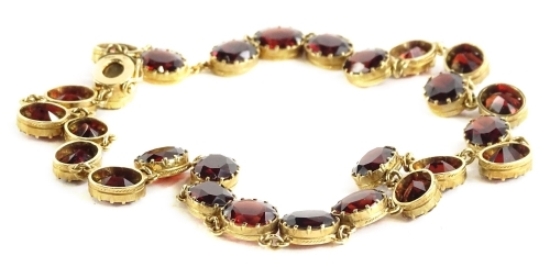 A garnet and 9ct mounted necklace, with twenty eight oval cut stones, stamped 375.