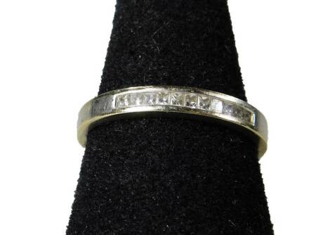 An 18ct white gold half hoop eternity ring, set with thirteen square cut diamonds, ring size N½, 2.7g all in.