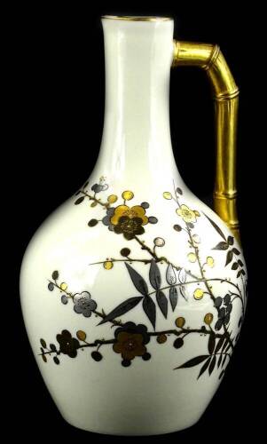 A Royal Worcester porcelain ewer, decorated in aesthetic style with gilt flowering oriental style branches, with a stylised bamboo handle, printed mark in green to underside, 27cm H.