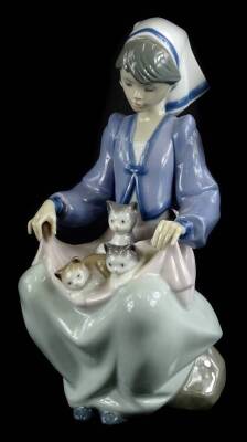 A Lladro porcelain figure of a lady holding three kittens, 22cm H.