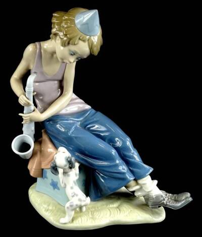 A Lladro porcelain figure group, modelled in the form of a seated girl with a saxophone and a dog, 26cm H.