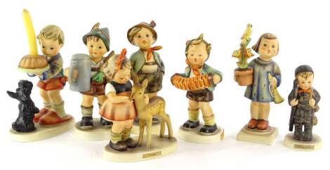 A collection of seven Hummel figures, modelled in the form of children with animals, flowers etc., to include a candlestick figure.