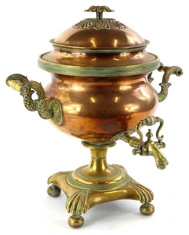 An early Victorian copper and brass two handled tea urn or samovar, with a pattera shaped handle, an engraved band, the handles cast with leaves, reeds etc., on a square base with bun feet, 43cm H.