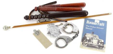 A collection of police related memorabilia, to include handcuffs, truncheons, badges, whistle etc.