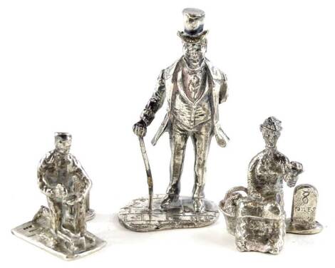 Three silver figurines, each modelled in the form of Dickensian type character, to include a pair each with a figure standing beside a milestone for 10 miles and 8 miles, and a gentleman with a walking stick. (English hallmarks marks indistinct), 4oz.