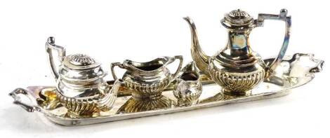 A miniature silver four piece tea set, each with part fluted decoration and a rectangular two handled tray, Birmingham 1973, 2oz.