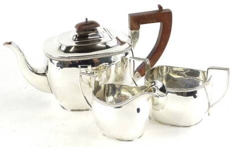 A George V silver three piece tea set, the teapot with composition knop and handle, Chester 1928, 28½oz gross.