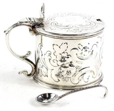 A Victorian drum shaped silver mustard pot, the hinged lid engraved to the top with a cartouche and indistinct initials, with a blue glass liner, London 1870, and a silver mustard spoon, 4½oz.