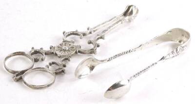 A pair of 19thC Irish silver sugar nips, decorated with scrolls, with shell shaped bowls, the circular hinge decorated with a flower and a pair of apostle type sugar tongs, 2oz.